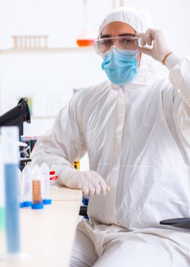 Laboratuvarda kimyasallar üzerinde çalışan genç bir kimyager.