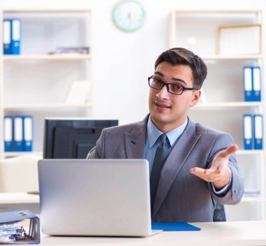 Ofisteki masasında oturan yakışıklı bir işadamı.