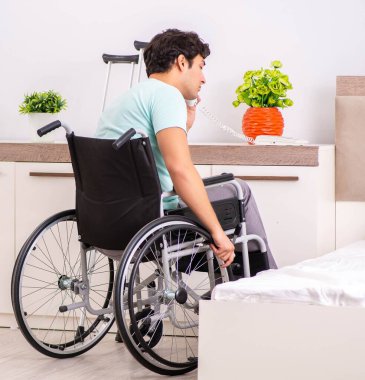 Genç yakışıklı engelli adam evde iyileşiyor.