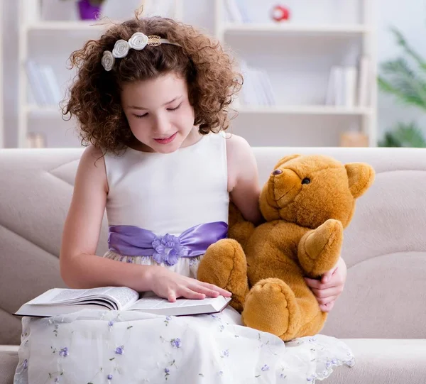 Μικρό όμορφο κορίτσι διαβάζει βιβλία στο σπίτι — Φωτογραφία Αρχείου