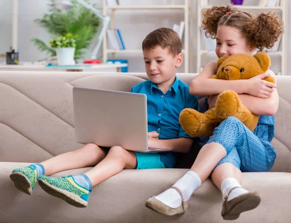 Dos niños sentados en el portátil en casa — Foto de Stock