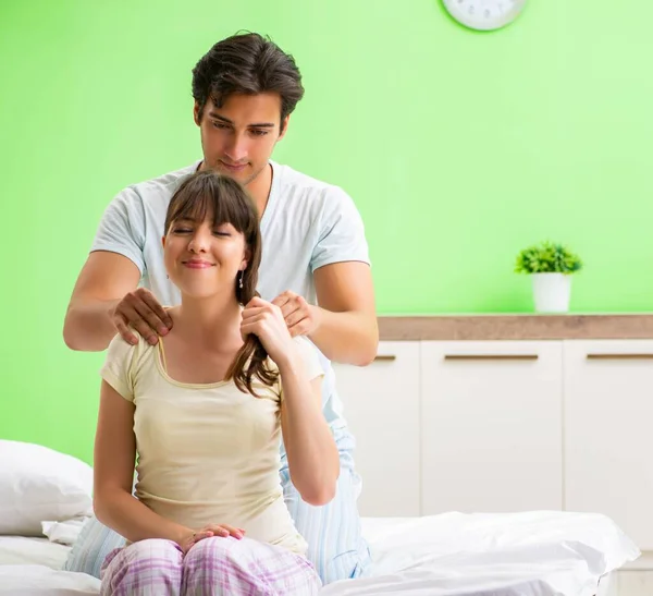 Man doet massage naar zijn vrouw in slaapkamer — Stockfoto