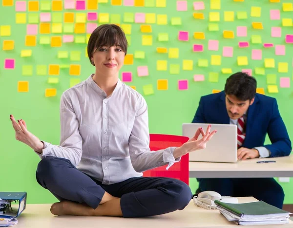 L'uomo e la donna in ufficio con molte priorità contrastanti in — Foto Stock