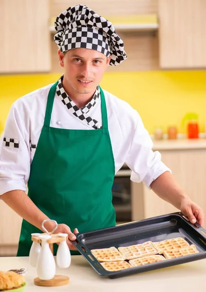 Mladý muž kuchař připravuje dort v kuchyni doma — Stock fotografie