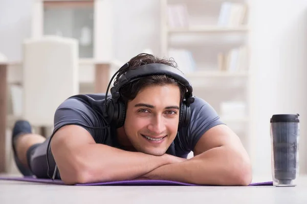 Hombre haciendo deportes en casa y escuchando música —  Fotos de Stock