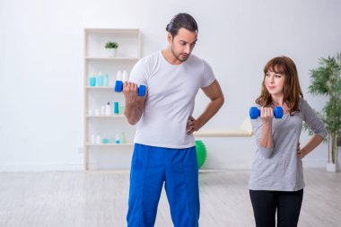 Kişisel koçla spor egzersizleri yapan genç bir kadın.
