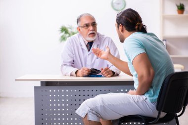 Genç erkek hasta, deneyimli doktoru ziyaret ediyor.