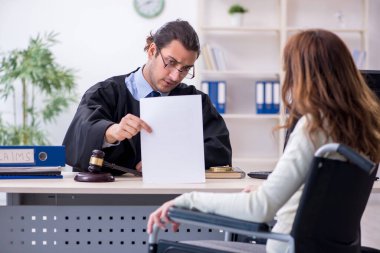 Yaralı kadın ve erkek yargıç mahkeme salonunda.