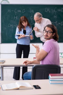 Eski kimya öğretmeni ve iki öğrenci sınıfta.