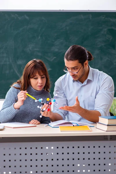 Young female student and male teacher in the classroom — Stock Photo, Image