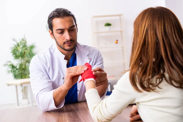 Jovem mão ferida mulher visitando médico traumatologista masculino — Fotografia de Stock