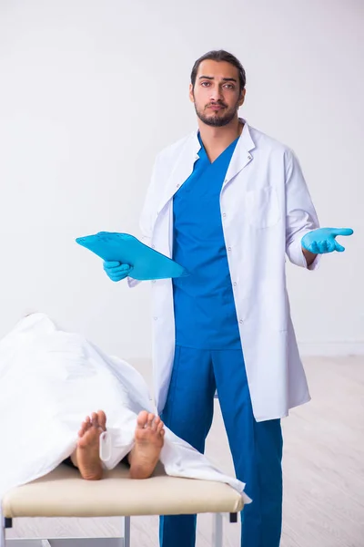 Police coroner examining dead body corpse in morgue — Stock Photo, Image