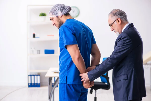 Male doctor in courthouse meeting with advocate