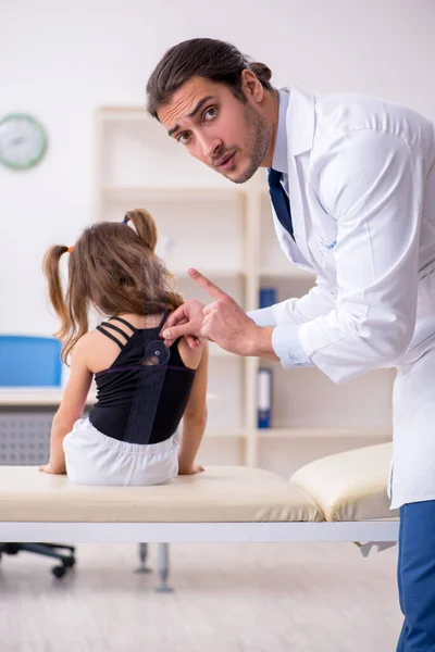 Menina pequena visitando jovem médico masculino — Fotografia de Stock