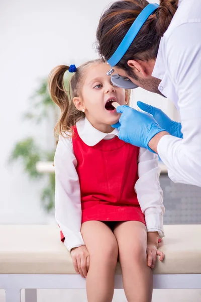 Klein meisje op bezoek bij jonge mannelijke arts otorhinolaryngoloog — Stockfoto