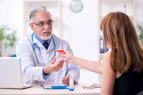 Giovane donna in visita vecchio medico maschio — Foto Stock