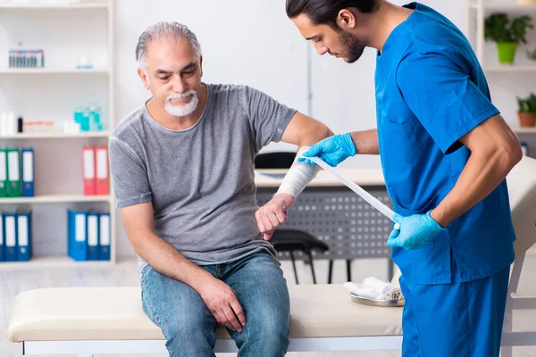 İlk yardım konseptinde genç erkek doktor ve yaşlı hasta. — Stok fotoğraf