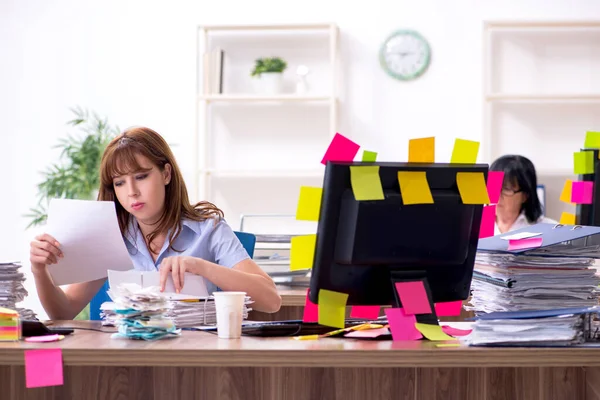 Två kvinnliga anställda och överdrivet arbete på kontoret — Stockfoto