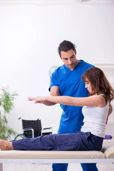 Injured woman visiting young male doctor osteopath — Stock Photo, Image