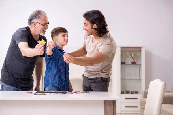 Tres generaciones de familia jugando rompecabezas juego — Foto de Stock