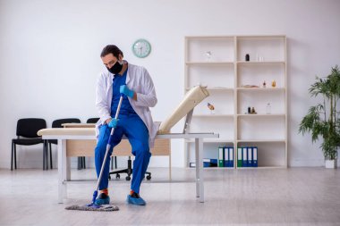 Genç erkek müteahhit salgın konseptinde dezenfekte kliniği
