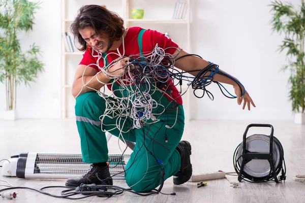 Grappige jonge mannelijke elektricien die binnen werkt — Stockfoto