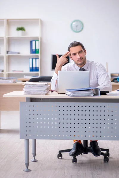 Giovane dipendente maschio infelice con il lavoro eccessivo — Foto Stock