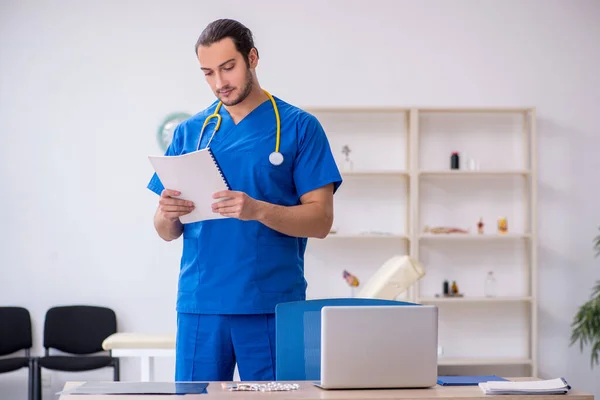 Ung manlig läkare som arbetar på kliniken — Stockfoto