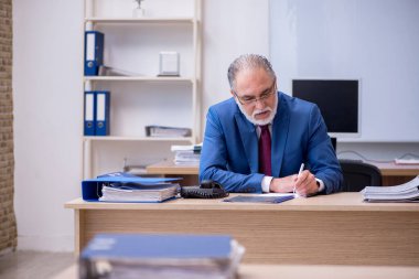 Ofiste çalışan yaşlı bir patron.