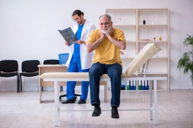 Yaşlı boyun yaralanması genç erkek doktor radyolojisti ziyaret ediyor.