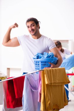 Evde ütü yapan genç bir çift.