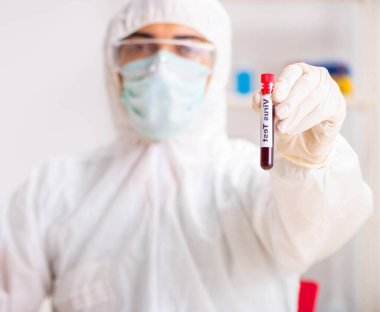 Genç yakışıklı laboratuvar asistanı hastanede kan örnekleri test ediyor.