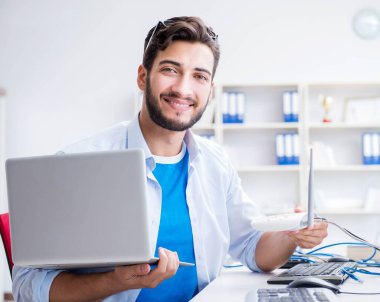 IT teknisyeni bilişim ekipmanlarına bakıyor.