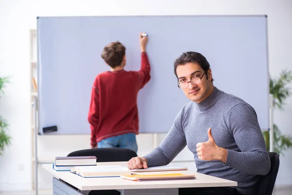 Ung manlig lärare och skolpojke i klassrummet — Stockfoto