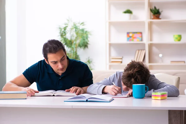 Far och son i examen förberedelse koncept — Stockfoto