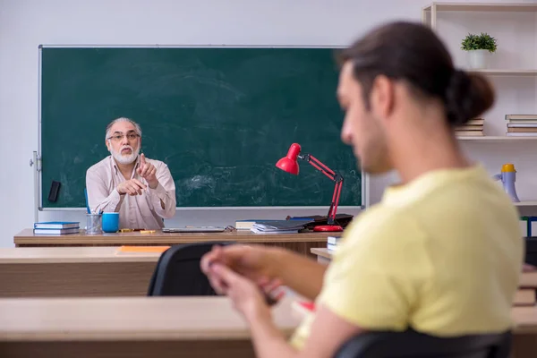 Starý učitel a mladý muž student ve třídě — Stock fotografie