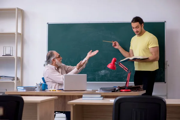 Viejo profesor y joven estudiante masculino en el aula — Foto de Stock