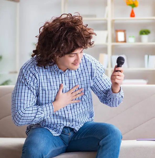 Zabawny człowiek śpiewa piosenki w karaoke w domu — Zdjęcie stockowe