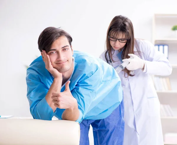Funny man getting ready for buttocks syringe shot — Stock Photo, Image