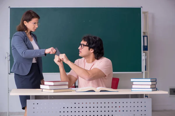 Oude vrouwelijke leraar en mannelijke student in de klas — Stockfoto