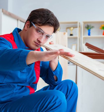 Genç marangoz ahşap kalaslarla çalışıyor.