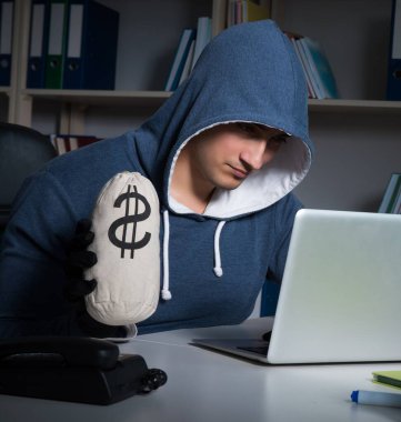 Genç hacker geceleri bilgisayarı hackliyor.