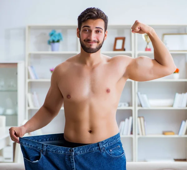 Человек в огромных брюках в концепции потери веса — стоковое фото