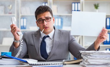 Ofiste sigara içen bir iş adamı elinde boş bir mesaj tutuyor.