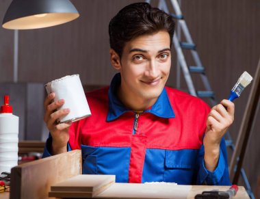 Genç adam ahşap parçaları DIY konseptinde yapıştırıyor.