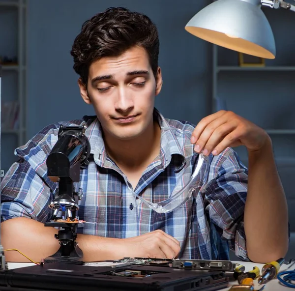Επισκευαστής που προσπαθεί να επισκευάσει laptop με miscroscope — Φωτογραφία Αρχείου