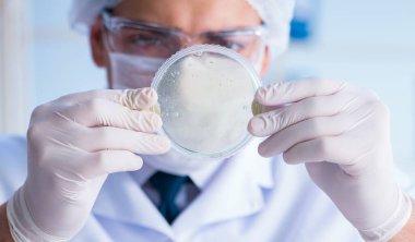 Bir laboratuarda deney yapan kadın bir bilim adamı.