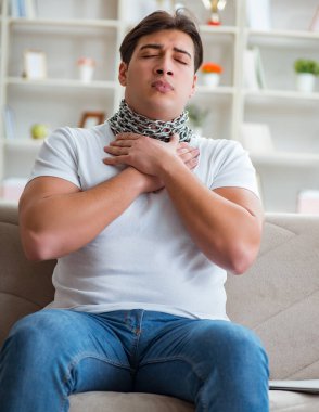 Genç adam boğaz ağrısı çekiyor.