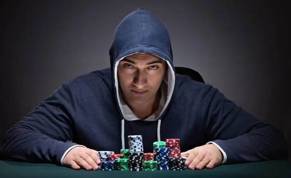 Jongeman draagt een hoodie met kaarten en chips gokken — Stockfoto