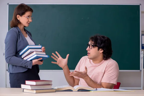 Gammal kvinnlig lärare och manlig student i klassrummet — Stockfoto